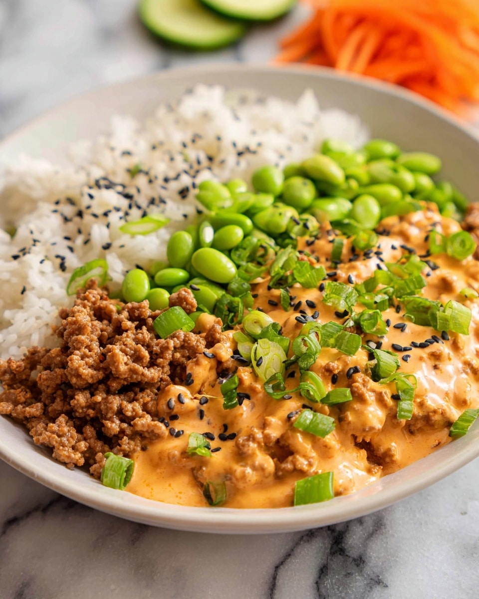 A white bowl is filled with a base layer of white rice on the left side, topped with green edamame beans. Next to the rice and edamame is a portion of thinly shredded bright orange carrots. On the right side, there is a layer of cooked ground meat covered with a creamy orange sauce. The dish is garnished with sliced green onions and black sesame seeds scattered over the sauce and vegetables. Slices of fresh cucumber are placed on the top right of the bowl. The background is a white marbled texture, and the photo has a close-up, bright look. photo taken with an iphone --ar 4:5 --v 7
