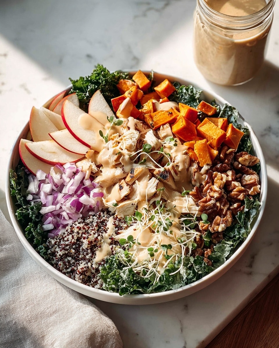 A large white bowl sits on a white marbled surface with a mix of bright and fresh layers. The bottom layer is deep green kale leaves spread evenly. On top, starting from the left, there are thinly sliced red and white apple pieces, next to small roasted orange cubes of sweet potato. Moving clockwise, finely chopped purple onions rest beside a light pile of creamy white sprouts. At the center, shredded light beige chicken pieces are garnished with small green herb sprigs. Around the chicken are dark brown walnuts and a grain mix with black and white quinoa. A creamy beige dressing is lightly drizzled over the top. In the background, a glass jar with more dressing stands with soft sunlight casting shadows. Photo taken with an iphone --ar 4:5 --v 7