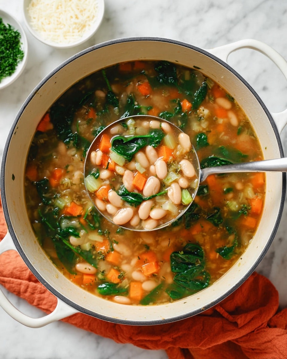 The image shows a close-up of a white pot filled with a vegetable bean soup, sitting on a white marbled surface with an orange cloth nearby. The soup has three main layers: a clear, light brown broth as the base, a middle layer with orange diced carrots, light green celery pieces, and white beans, and a top layer of dark green spinach leaves scattered throughout. A silver ladle filled with the same soup is held inside the pot, displaying the layered ingredients clearly. In the background, there are two white bowls, one with some parsley and the other with grated cheese. Photo taken with an iphone --ar 4:5 --v 7