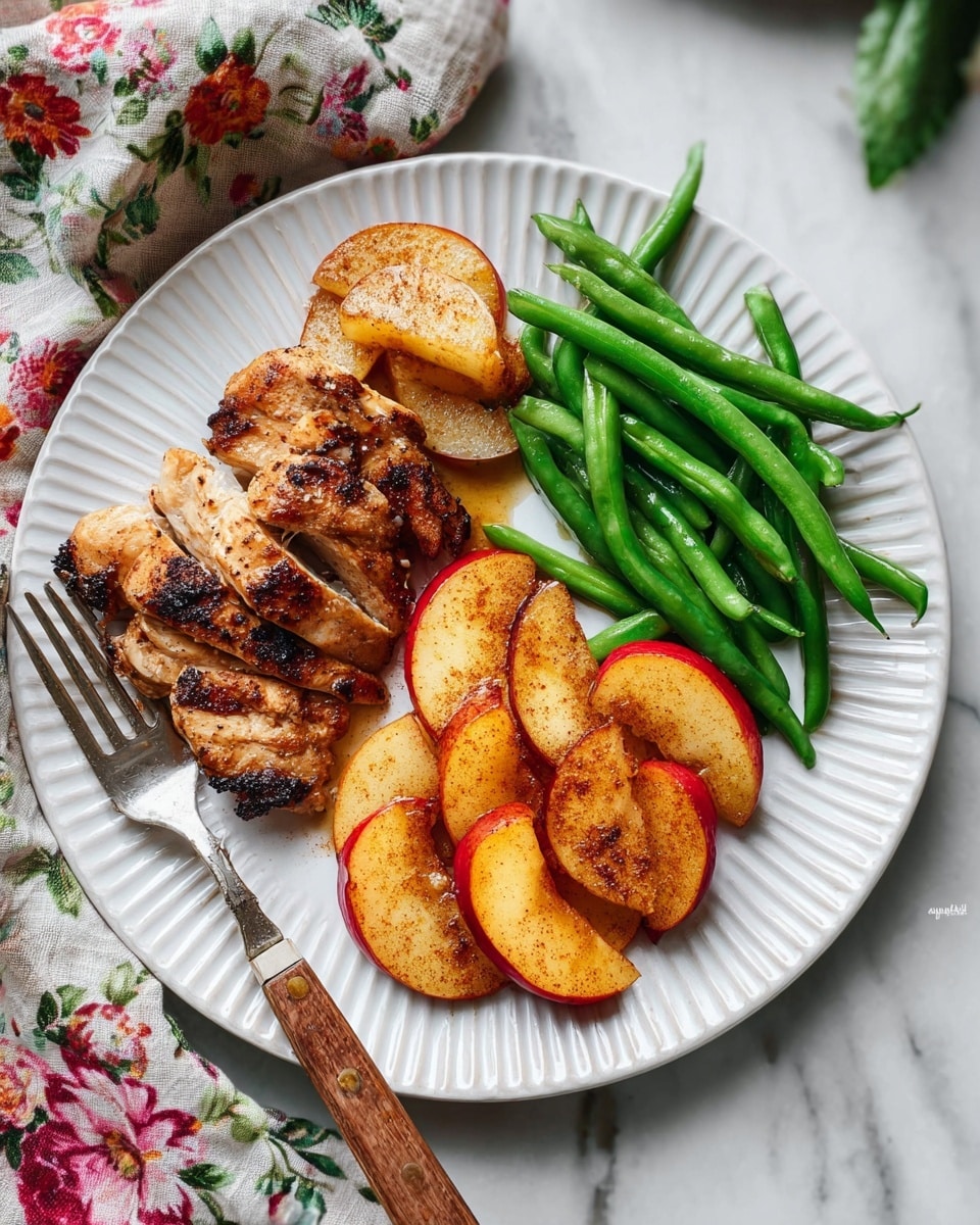 The image shows a black cast iron pan filled with four golden brown, crispy chicken thighs with a textured, slightly charred skin. Around and beneath the chicken are several chunks of glossy red-skinned apples and soft, cooked onions that have a light golden color. Bright green sprigs of fresh rosemary and thyme are arranged on top and between the chicken pieces, adding a fresh contrast. The dish sits on a white marbled textured surface. Photo taken with an iphone --ar 4:5 --v 7