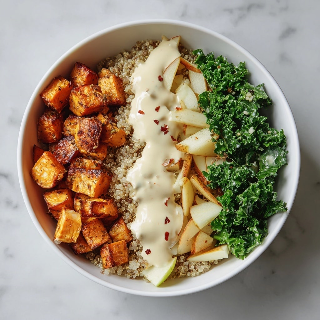 A white bowl filled with a base layer of cooked light beige quinoa with some small red quinoa seeds mixed in, topped with three distinct sections: on the left, deep green curly kale leaves; in the middle, roasted light golden potato chunks with slight brown grill marks; and on the right, roasted bright orange butternut squash cubes with darker charred spots. Creamy white sauce with visible black mustard seeds is drizzled generously over the central and right sections, adding a smooth texture and contrast against the grains and roasted vegetables. The bowl is placed on a wooden surface with a white marbled background. photo taken with an iphone --ar 4:5 --v 7