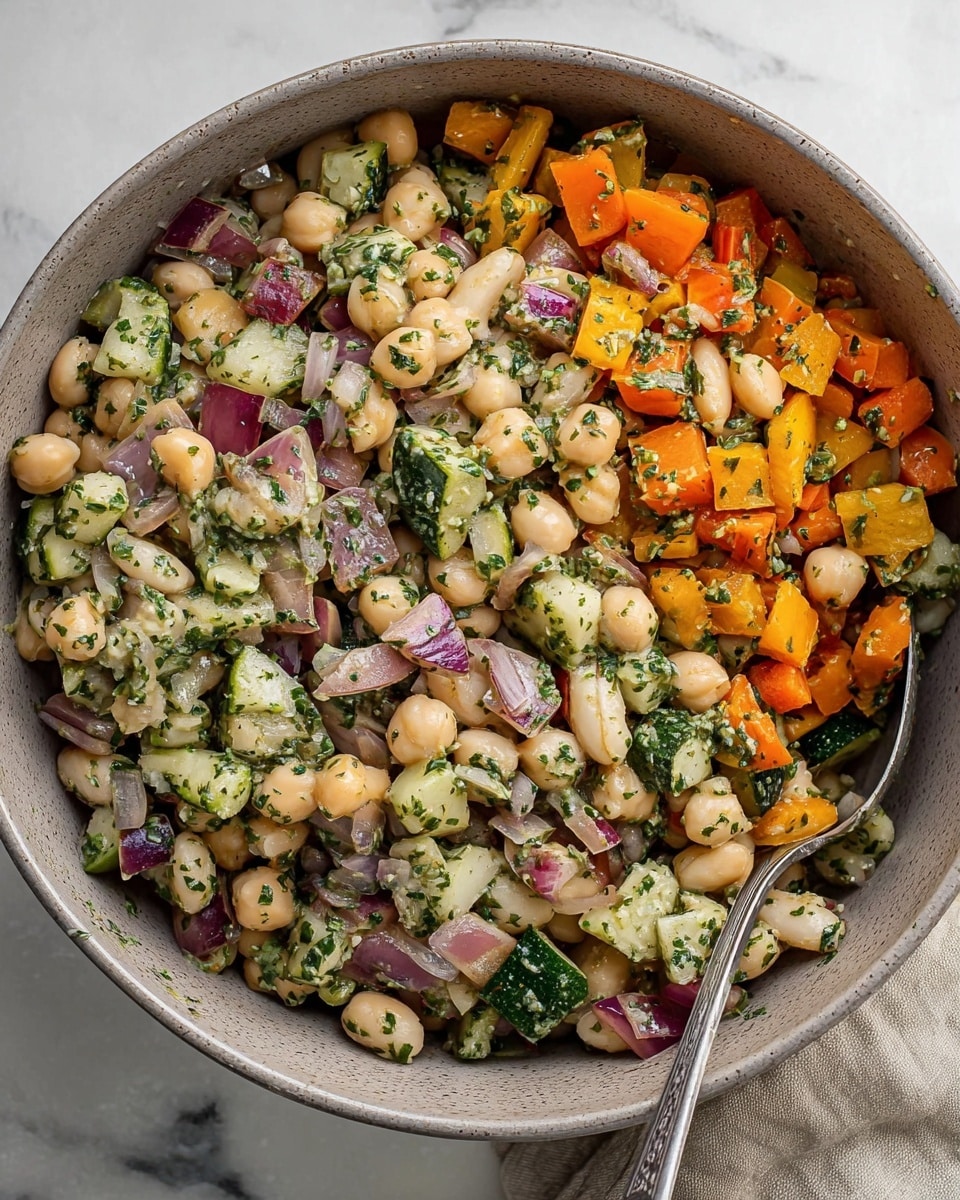 A close-up of a pita bread folded in half, filled with a colorful mix of chickpeas, diced orange bell peppers, green and purple vegetables, and chopped herbs all on top of a creamy white spread inside the pita. The chickpeas are round and light beige, with bright orange and green chopped veggies mixed throughout, showing texture and freshness. A woman's finger is gently holding the pita on one side, resting on a white plate with a brown rim, all placed on a white marbled surface. Photo taken with an iphone --ar 4:5 --v 7