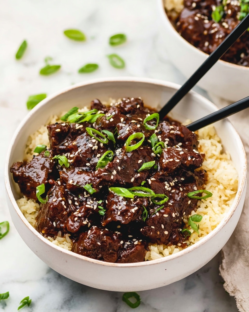 A white shallow bowl filled with rich, dark brown barbecue beef, shredded and coated in thick sauce. The beef is glossy with small bits of green onions sprinkled on top, adding a fresh touch. The sauce looks sticky and smooth, pooling slightly at the bottom. A silver spoon is placed inside the bowl, lifting a clump of tender meat. The bowl sits on a white marbled surface with blurred green onions in the background, giving a fresh and rustic feel. photo taken with an iphone --ar 4:5 --v 7