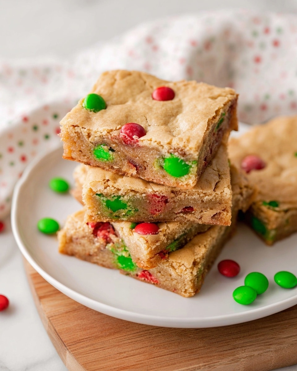 A rectangular baked blondie with a light golden brown cracked top layer is seen resting on white parchment paper over a black cooling rack, placed on a white marbled surface. The blondie is studded with bright red and green candy-coated chocolates spread evenly across the surface, some slightly sinking in while others sit on top. The edges form a slightly thicker crust with a crisp texture, while the interior appears soft and chewy. The overall look is warm and inviting with festive red and green specks set against the pale golden base. Photo taken with an iphone --ar 4:5 --v 7
