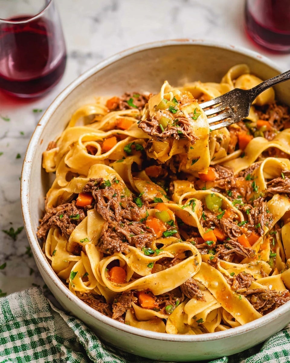 A close-up view of a black slow cooker filled with a hearty dish of wide egg noodles mixed with shredded beef and small pieces of orange carrot in a thick brown sauce. The noodles are soft and slightly curled, spread evenly throughout the dish, with the beef appearing tender and juicy, scattered on top and underneath. The sauce glistens and coats the noodles and meat, pooling slightly at the bottom. A metal spoon rests inside on the right side, partly submerged in the dish. The whole cooker sits on a white marbled surface photo taken with an iphone --ar 4:5 --v 7