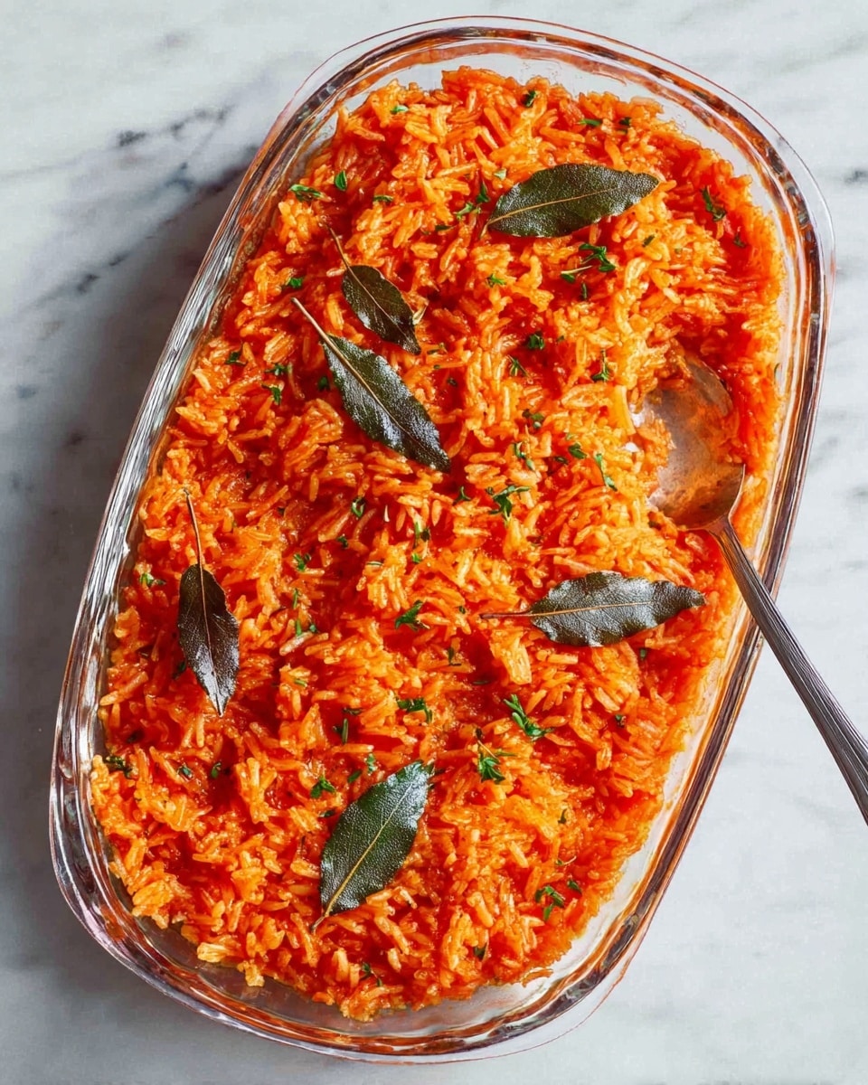 The image shows a close-up of a glass baking dish filled with cooked rice that is bright orange-red in color, mixed with small bits of green herbs sprinkled throughout. The rice texture is soft and slightly sticky, with visible grains. A silver spoon is placed inside the dish, scooping some rice from the bottom right corner. The dish rests on a white marbled surface. Photo taken with an iphone --ar 4:5 --v 7