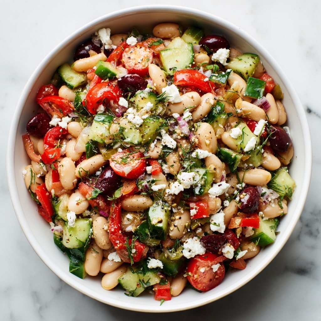 A white bowl is filled with a colorful salad made of four main layers. The bottom layer is small white beans scattered throughout. The second layer is chopped green cucumber pieces, fresh red cherry tomatoes sliced in half, and small bits of red bell pepper mixed evenly. The third layer has small pieces of black olives and finely chopped purple onion. The top layer has small sprigs of green parsley and bits of white feta cheese crumbled on top. Two silver ornate spoons rest inside the bowl, placed diagonally with the handles leaning over the edge. The bowl sits on a white marbled surface with a blue cloth underneath. photo taken with an iphone --ar 4:5 --v 7