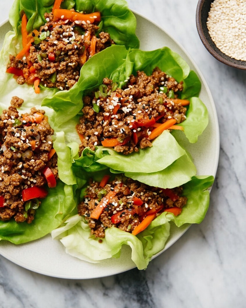 The image shows three lettuce wraps arranged on a white plate, each wrap made from bright green lettuce leaves forming a soft cup shape. Inside the lettuce cups, there is a filling of small, crumbly cooked ground meat mixed with small orange carrot strips and diced red bell peppers, creating a mix of brown, orange, and red colors. The meat filling is sprinkled with white and black sesame seeds that add small specks of contrast on top. The plate sits on a white marbled surface, and on the right side, part of a small round bowl filled with white sesame seeds is visible. Photo taken with an iphone --ar 4:5 --v 7
