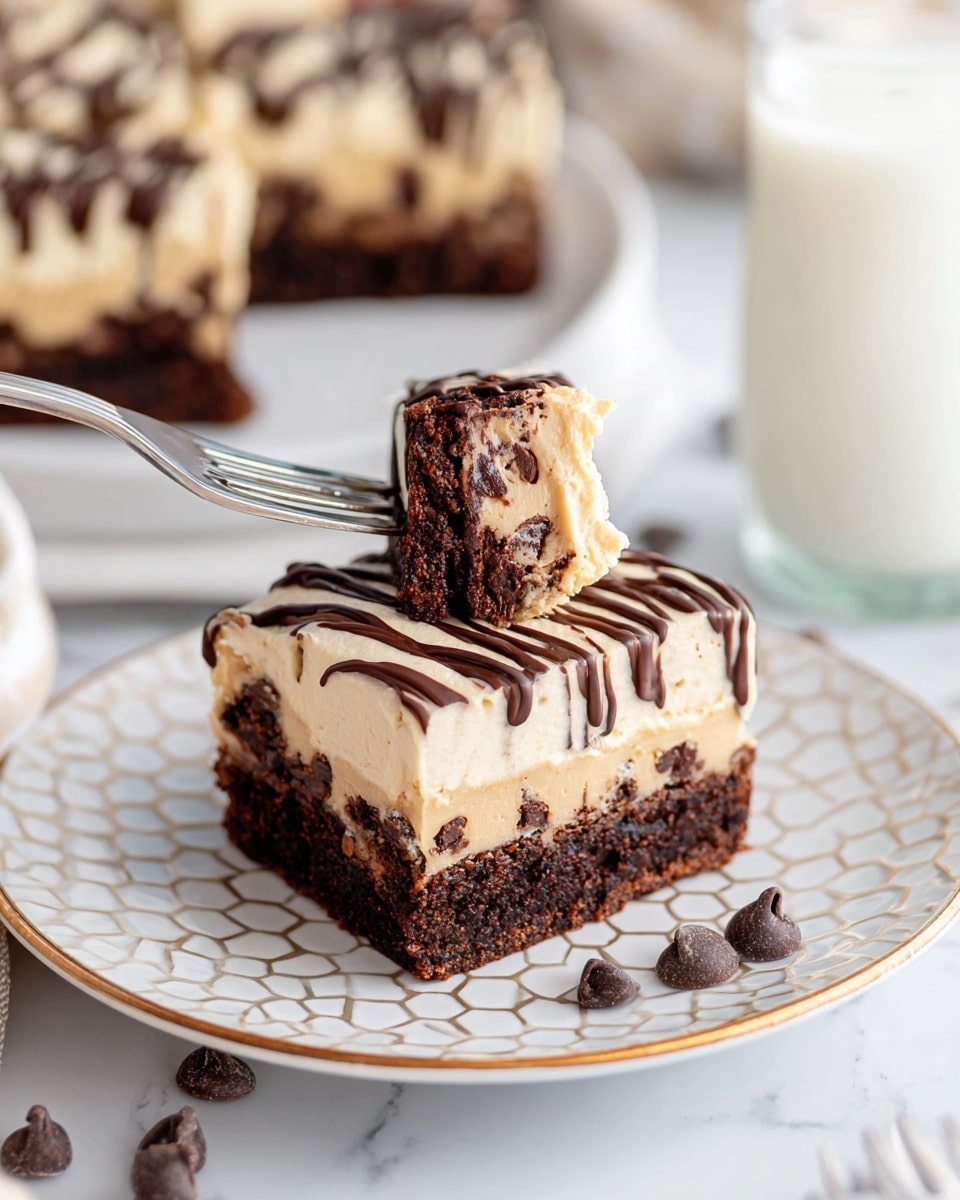 A square dessert bar with two main layers sits on a white plate held by a woman's hand. The bottom layer is thick, dark brown, and dense, looking like a rich chocolate brownie with visible chunks of chocolate. The top layer is lighter brown, creamy, and smooth, resembling a fluffy mousse or frosting. Dark chocolate drizzle is artistically spread across the top light layer, dripping slightly down the sides. A white swirl of whipped cream is placed in the center on top. Several chocolate chips are scattered around the base on the plate. The background has a white marbled texture with more of the dessert slightly blurred in the distance, creating a soft, inviting feel. Photo taken with an iphone --ar 4:5 --v 7