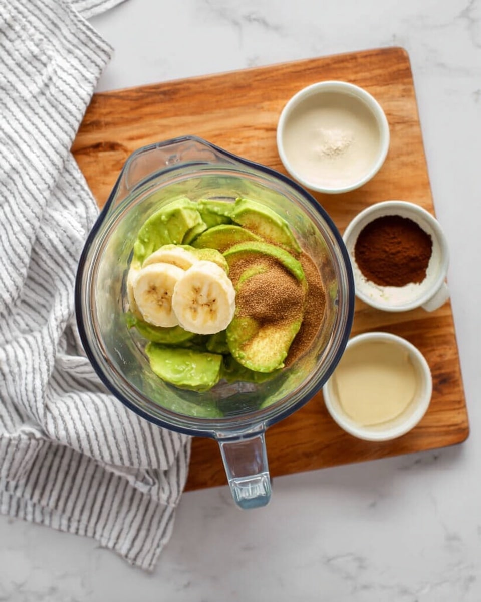 A close-up of two white small round bowls filled with smooth, thick dark brown chocolate pudding topped with small light gray chocolate chips. One bowl is closer with a silver spoon lifting some pudding showing its creamy texture, while the other bowl is in the background. The bowls are placed on a light wooden board with scattered gray chocolate chips around them. A striped tan and black cloth is softly out of focus in the background over a white marbled surface. Photo taken with an iphone --ar 4:5 --v 7